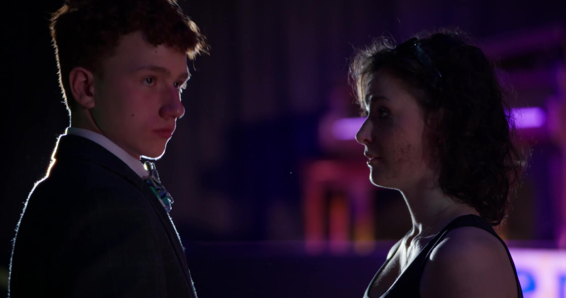 Ryan and his date share a quiet moment, lit by a single spotlight.