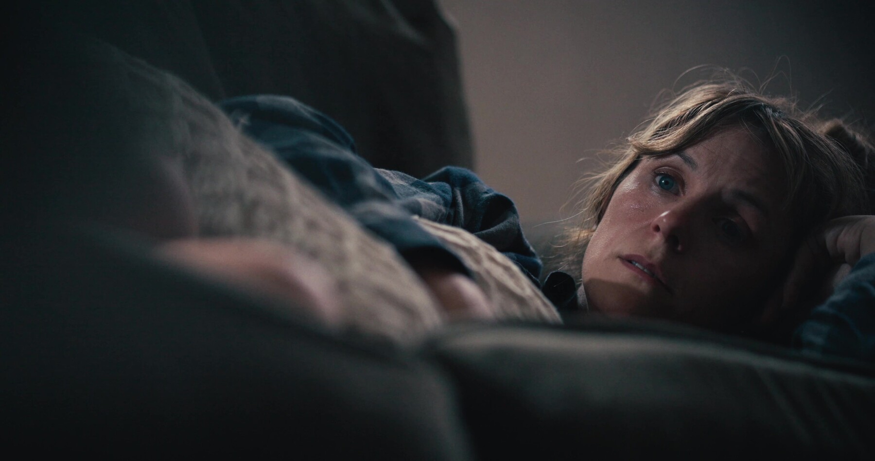 Maggie lies on the couch, tearful, staring into the distance.